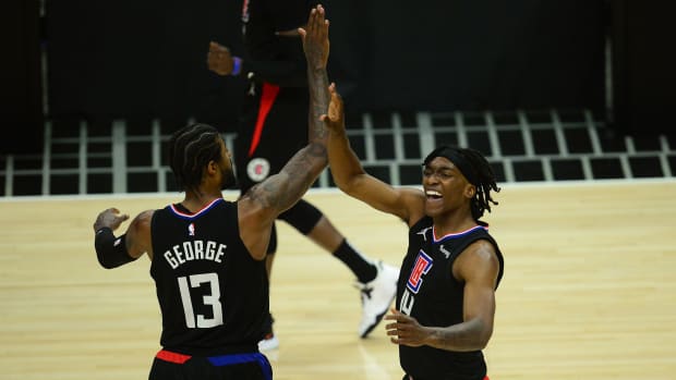 Jun 14, 2021; Los Angeles, California, USA; Los Angeles Clippers guard Terance Mann (14) reacts with guard Paul George (13) after scoring a basket and drawing a foul against the Utah Jazz during the first half in game four in the second round of the 2021 NBA Playoffs. at Staples Center. Mandatory Credit: Gary A. Vasquez-USA TODAY Sports